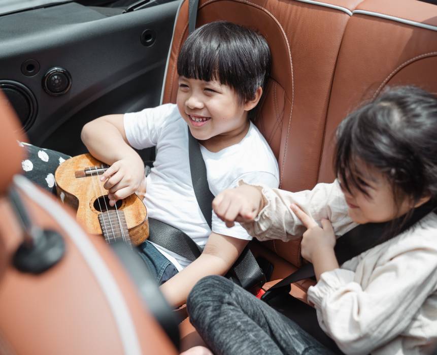 Two children are sitting in a car seat.