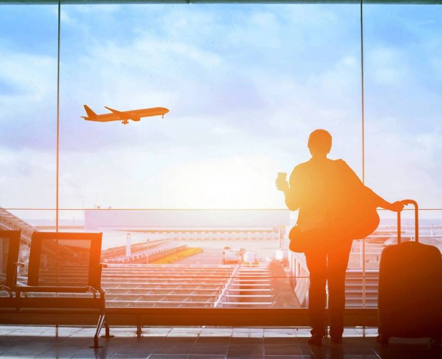 A person standing in front of an airport window.