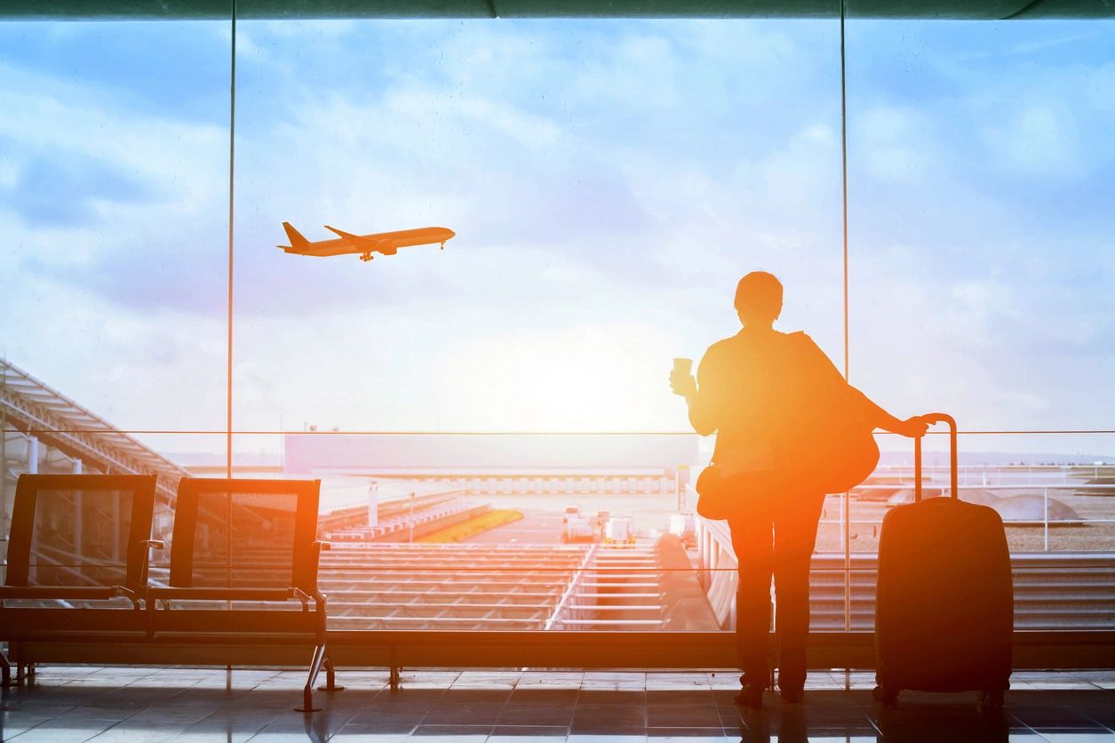 A person standing in front of an airport window.